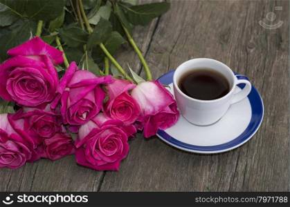 big bouquet of roses and cup of black coffee
