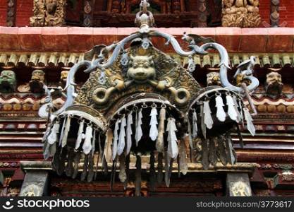 Big bronze lamp and wall of temple Changu Narayan