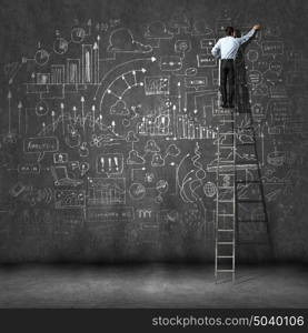 Big business plan. Rear view of businessman standing on ladder and drawing business sketch on wall