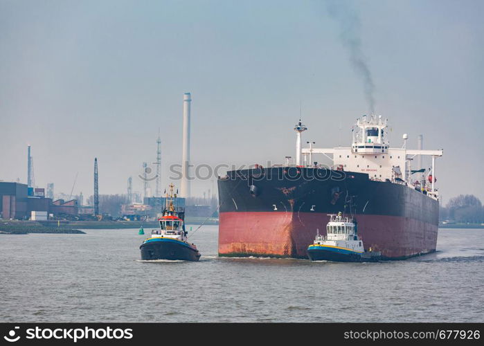 Big Cargo Containers Boat with Goods cargo Stack at the Pier docks port waiting for international sea freight transportation in Rotterdam Port of Netherlands