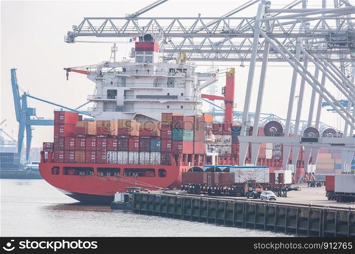 Big Cargo Containers Boat with Goods cargo Stack at the Pier docks port waiting for international sea freight transportation in Rotterdam Port of Netherlands