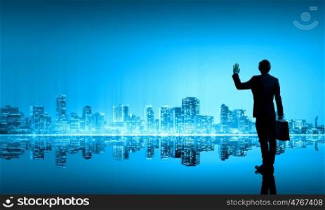 Big city life. Businessman standing with back against night city panoramic view