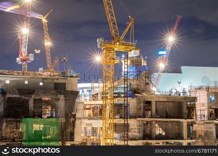Big Construction site at dusk with working crane moving