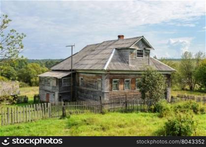 Big country wooden house with mansard in russian village