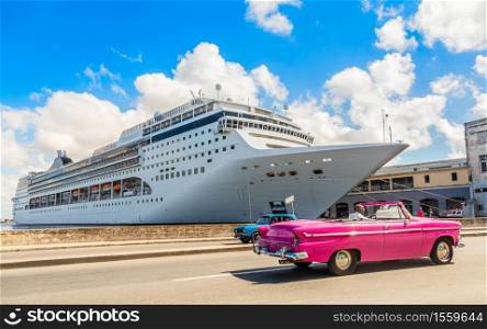 Big cruise ship docked in port of Havana and road with retro old car, Cuba