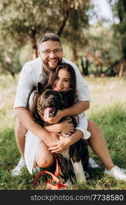 Big dog for a walk with a guy and a girl on the green prairie