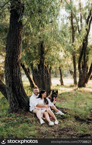 Big dog for a walk with a guy and a girl on the green prairie