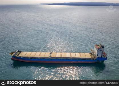 Big empty ship at sea. Aerial top view of cargo ship vessel import-export sailing.