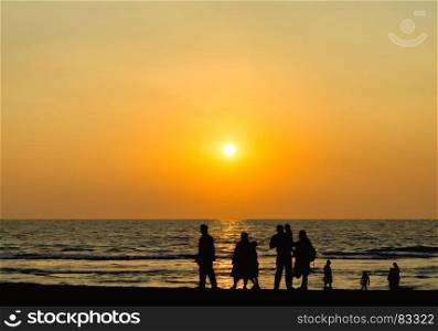 Big family silhouette meeting vivid orange sunset ocean horizon abstraction. Big family silhouette meeting vivid orange sunset ocean horizon