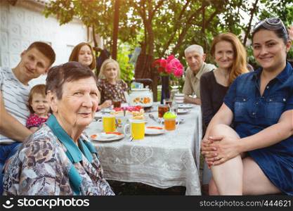 big family sitting at a table in the garden