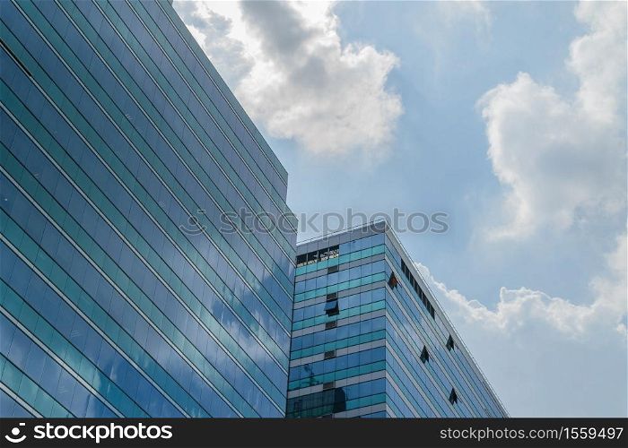 Big glass building with blue sky and white cloud