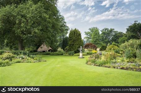 big green gardenwith ngreen grass flowers and gardenhouse. big park with plants green field