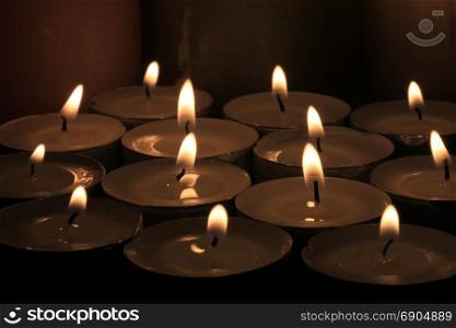 Big group of burning votive candles or votive lights