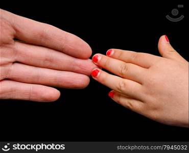 Big hand palm meeting small girl hand with cracked pink nail paint isolated on black