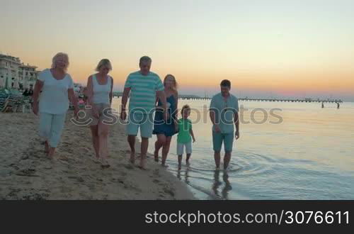 Big happy funny family walks on the beach and dancing at the same time against evening sea background Piraeus, Greece