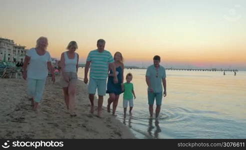 Big happy funny family walks on the beach and dancing at the same time against evening sea background Piraeus, Greece