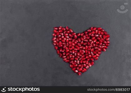 big Heart of fresh pomegranate on a background of dark stone Closeup. Romantic Valentines day concept.. big Heart of fresh pomegranate on a background of dark stone Closeup. Romantic Valentines day concept
