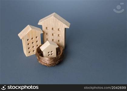Big houses and small house in the bird nest. Parenting metaphor. Investing in real estate. Construction industry, development. Design project. Realtor services. Mortgage. Affordable social housing