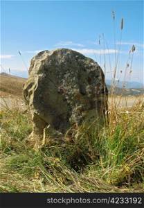 Big lonely stone near the road. Caucasus landscape
