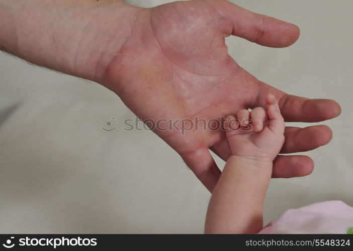 big man hand holding small baby hand