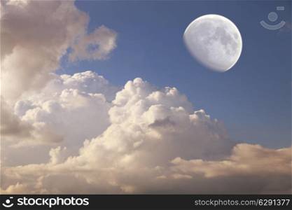 big moon in the daytime sky with clouds