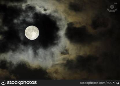 big moon over the clouds in a dark night