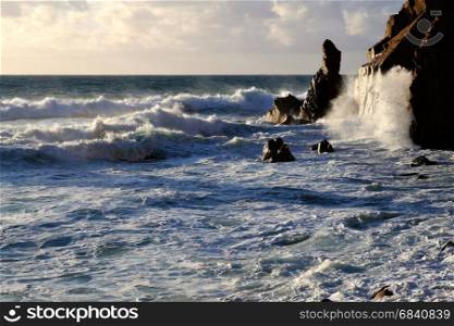 Big ocean wave crashing rock