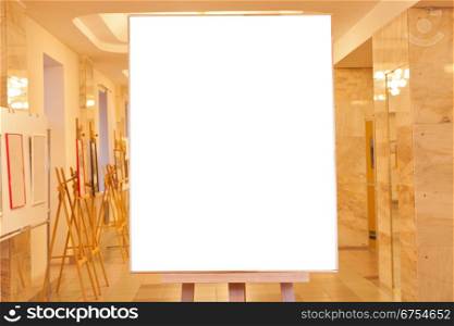 big picture frame with white cut out canvas on easel with yellow light gallery background
