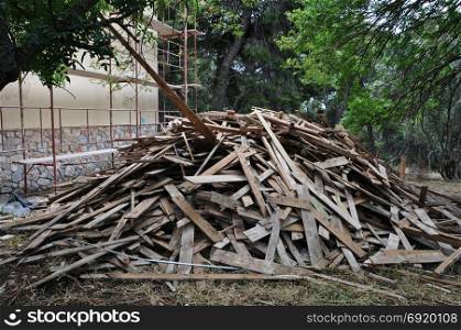 Big pile of old wooden planks at construction site.