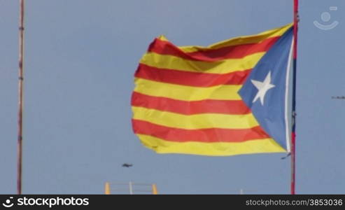 Big pro-independent Catalonia flag next to the Mediterranean sea.Flag waving in the wind.Pro-independence Catalonian flagstaff in a windy day.