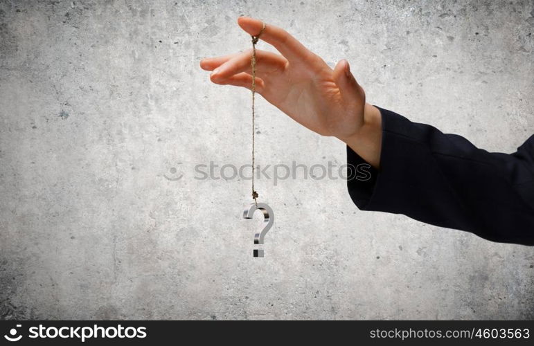 Big question. Close up of businessman hand and question sign hanging on finger