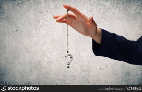 Big question. Close up of businessman hand and question sign hanging on finger