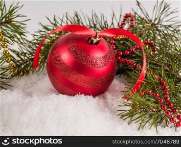 Big red Christmas ball lying on snow