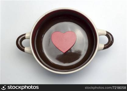 Big red heart at the bottom of the soup tureen on white background.. Big red heart at the bottom of the tureen.