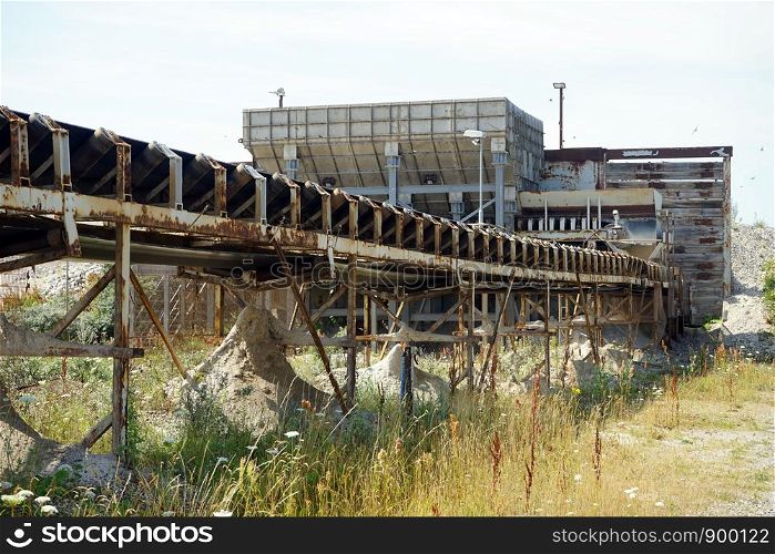 Big rusty conveyor and quarry
