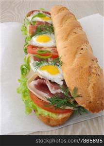 Big sandwich with ham, tomato and fried quail egg