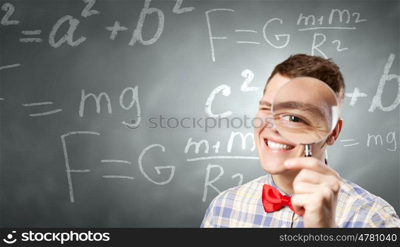 Big science head. Young funny science man looking in magnifier