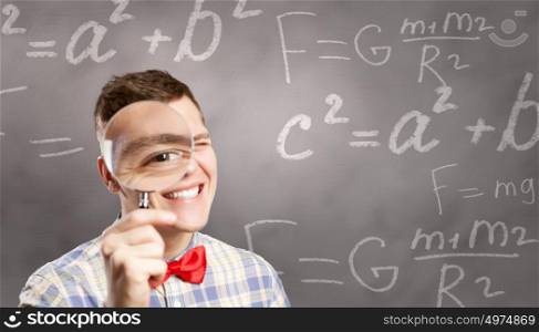 Big science head. Young funny science man looking in magnifier