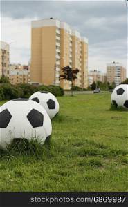 Big soccer balls on the green lawn
