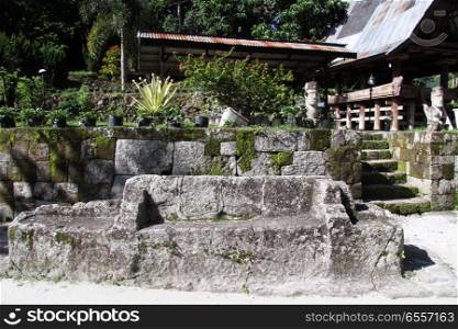 Big stone chair near batak house in Ambarita village, Indonesia