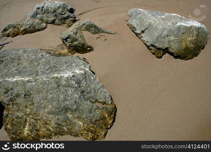 Big stones in the brown sand beach shore Mediterranean sea