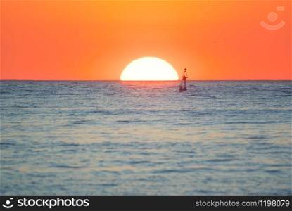 Big Sun and sea surface. Sunset on the beach