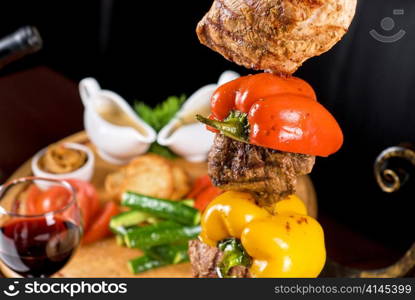 Big tasty roasted meat cuts at skewer on a decorated table