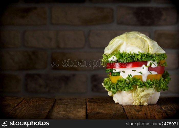Big vegan burger on wooden table still life with copy space. Pure organic vegetable hamburger concept.