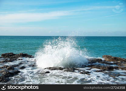 Big waves breaking on the shore with sea foam