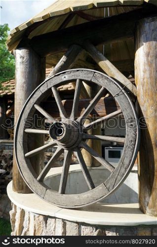Big wheel and old well inear farm house in the village