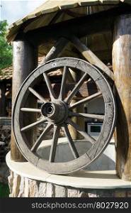 Big wheel and old well inear farm house in the village