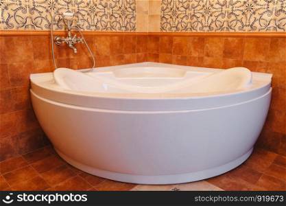 Big white bathtub in a middle of industrial loft bathroom style with grunge cement wall. Big white bathtub in a middle of industrial loft bathroom style with grunge cement wall.