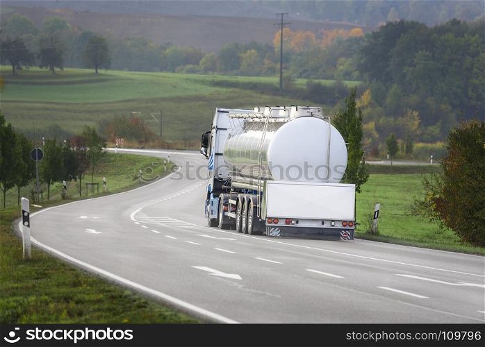 Big white tanker truck drives on a countryside road, outside the german city Schwabisch Hall, Baden Wurttemberg, Germany