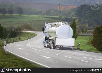 Big white tanker truck drives on a countryside road, outside the german city Schwabisch Hall, Baden Wurttemberg, Germany